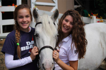 Two girls and a white horse.